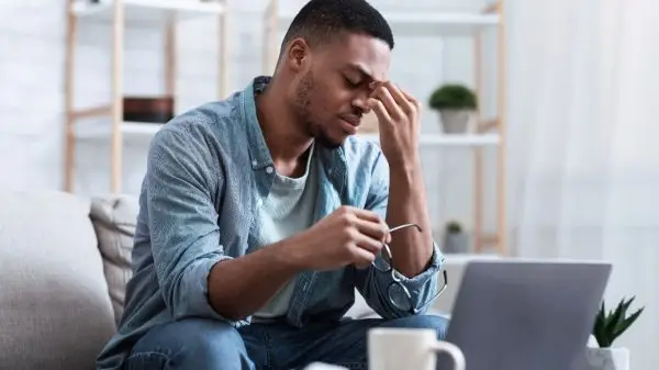 Person working on a laptop with focused expression, representing productivity and efficiency during client onboarding